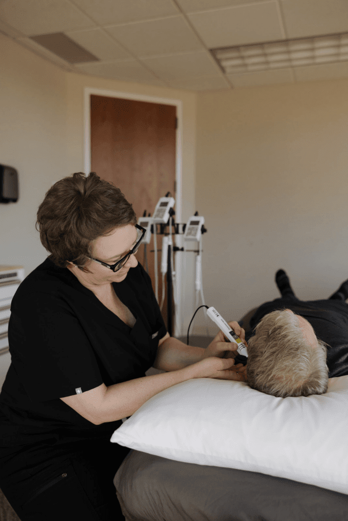 Acupuncturist applying electro-acupuncture therapy at a Fort Collins pain clinic